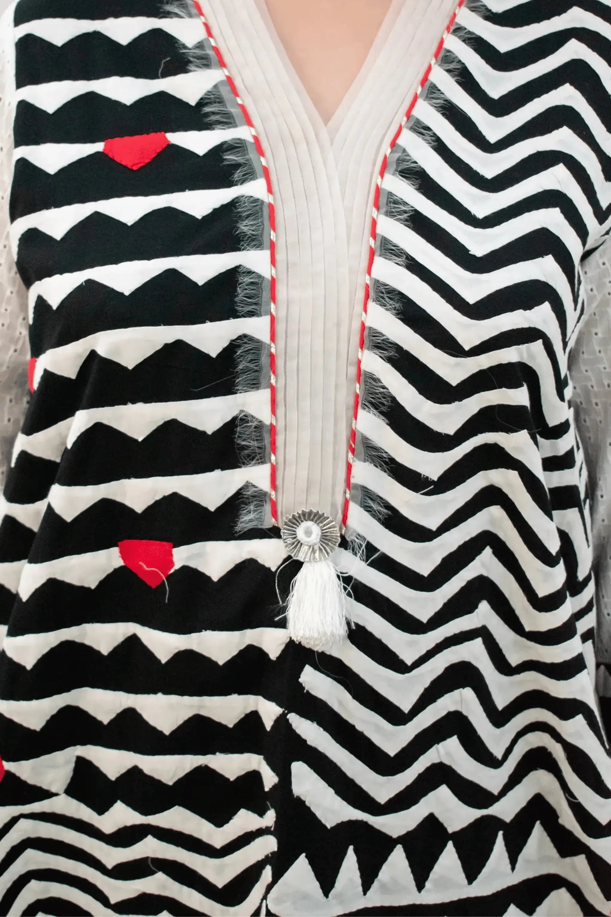 Aztec shirt neckline with tassel detail and red accent embroidery.