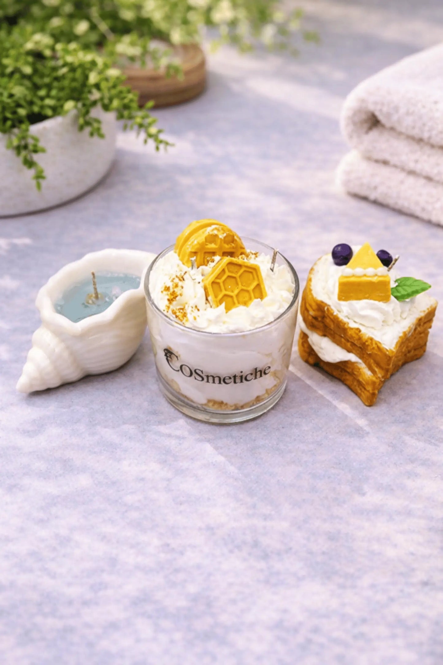 Food-inspired scented candles from the Cosmetiche Baking Festive Bundle showcasing bread, butter, honey cheese, and seashell candle designs.