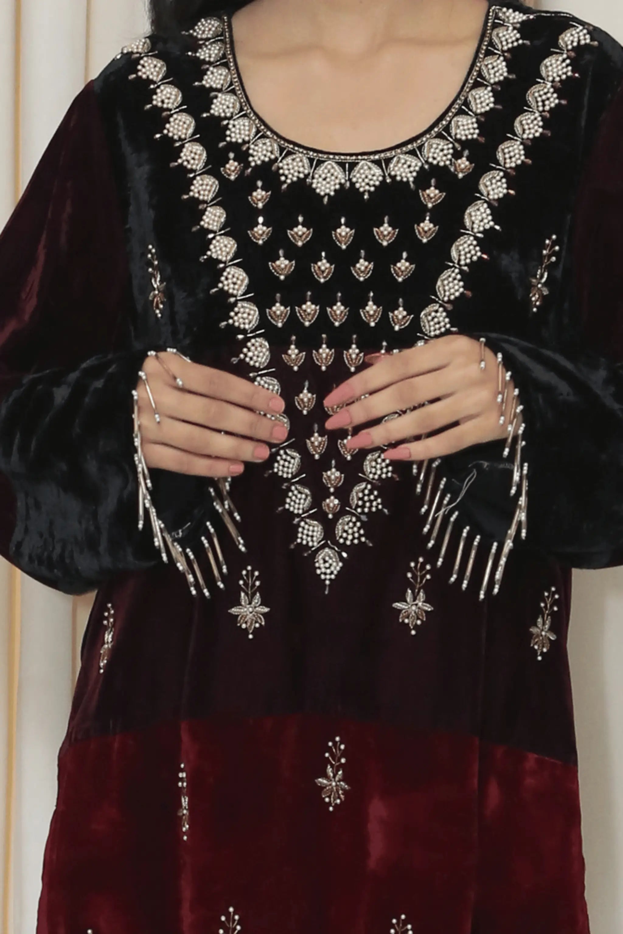 Close-up of intricate embroidered neckline with bead and pearl detailing.