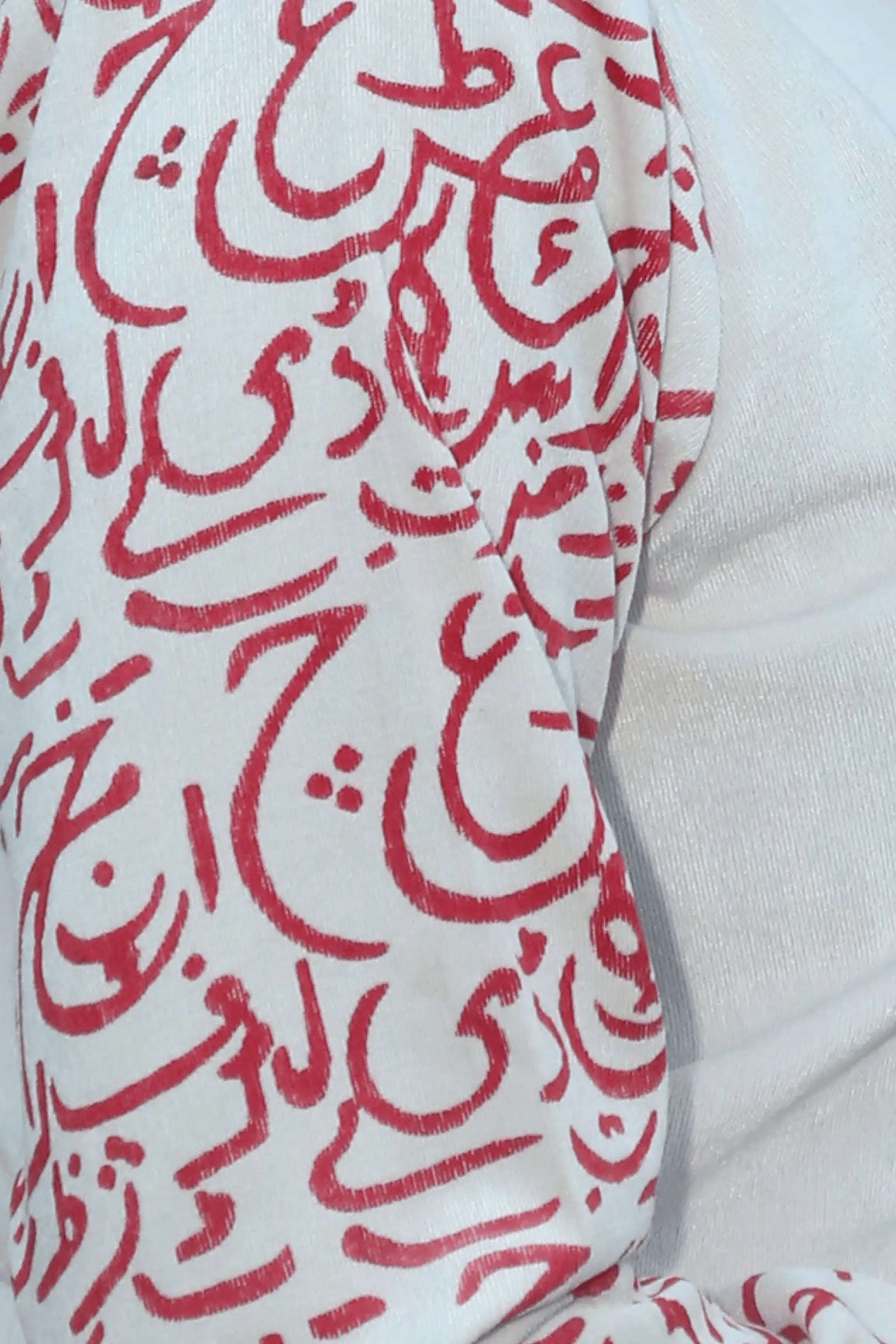 Close-up of red block print calligraphy on sleeves and hem