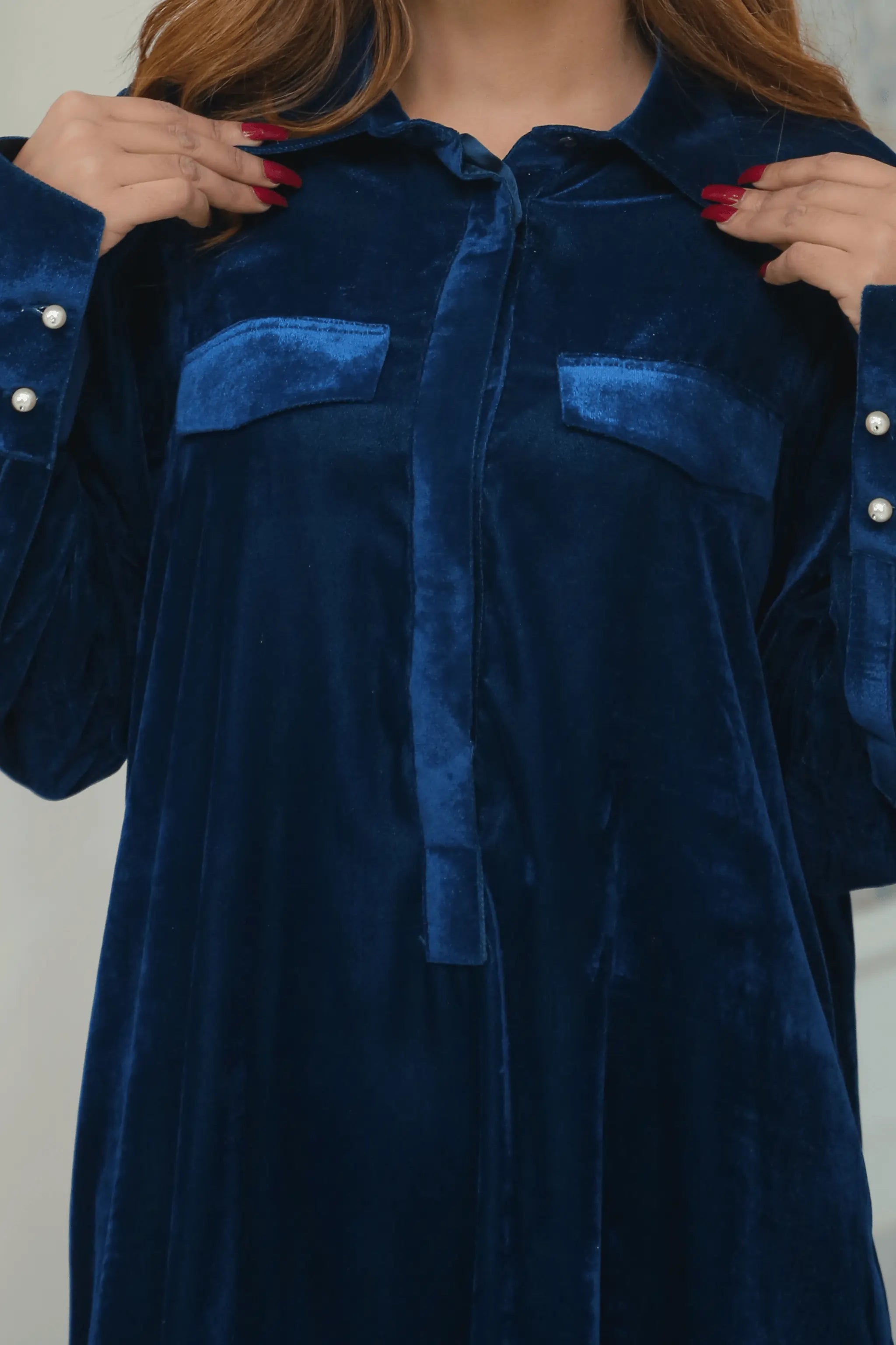 Close-up of royal blue velvet shirt with flap pockets.