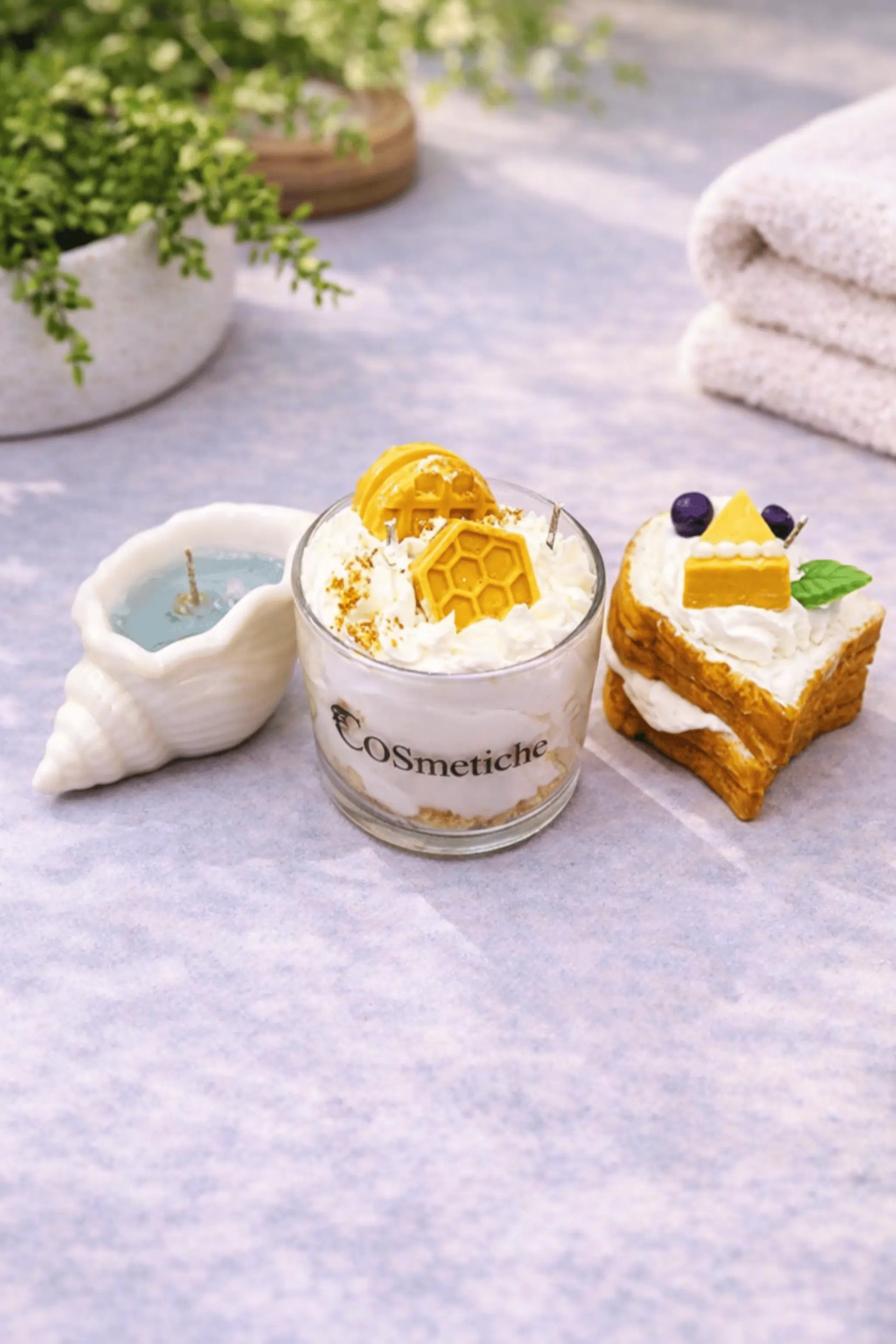 Food-inspired scented candles from the Cosmetiche Baking Festive Bundle showcasing bread, butter, honey cheese, and seashell candle designs.