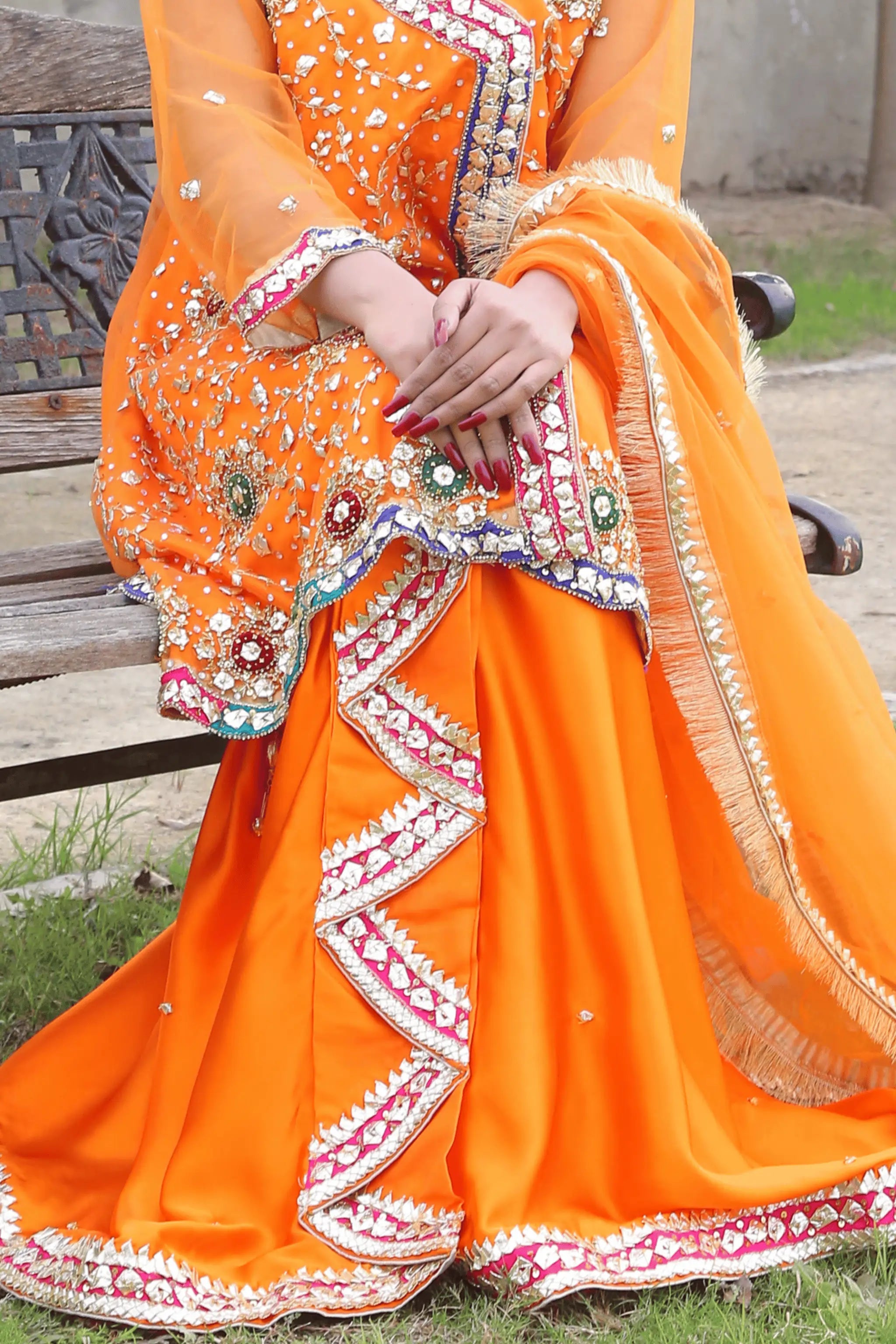 Model wearing Amber Dusk – orange 3 piece wedding dress with organza shirt and silk loungi.